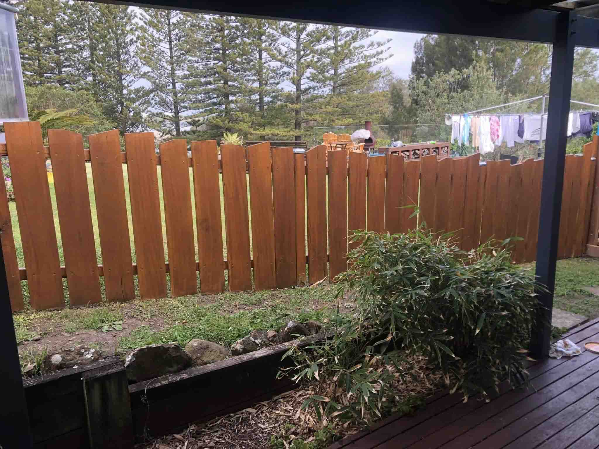 Stained timber paling fence seen from a covered deck