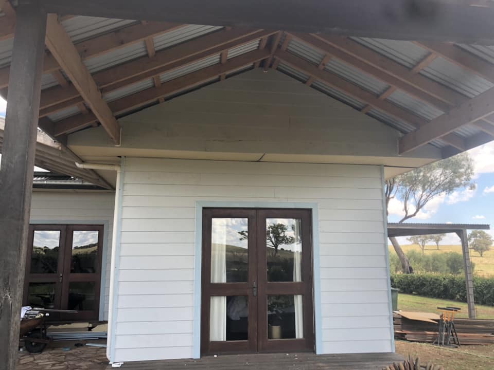 Exposed timber rafters under a gabled roof over French doors