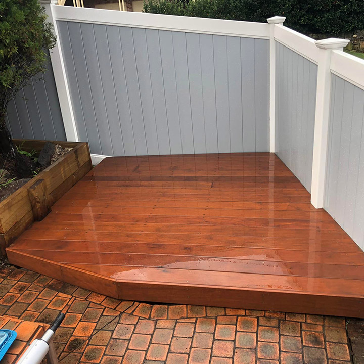 After: new timber deck filling the fenced corner beside brick paving