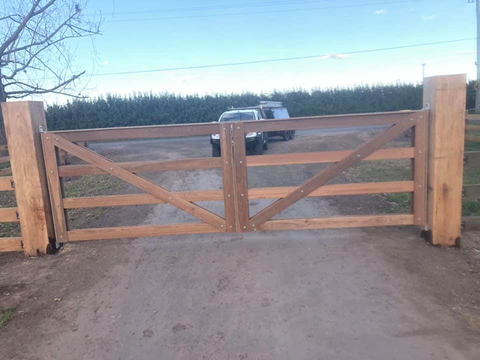 Double timber farm gates across a rural driveway