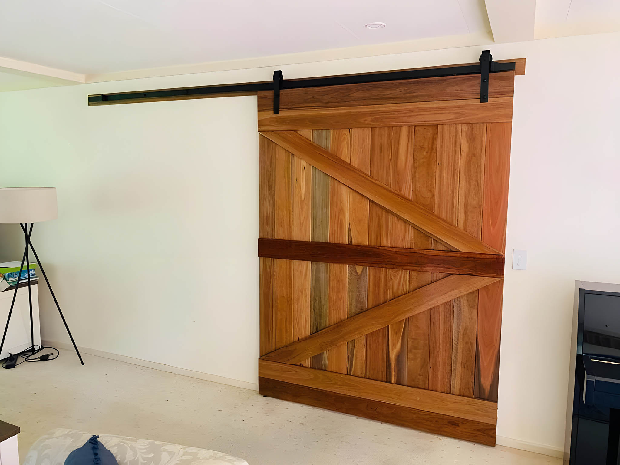 Timber barn door on a black sliding track in a living room