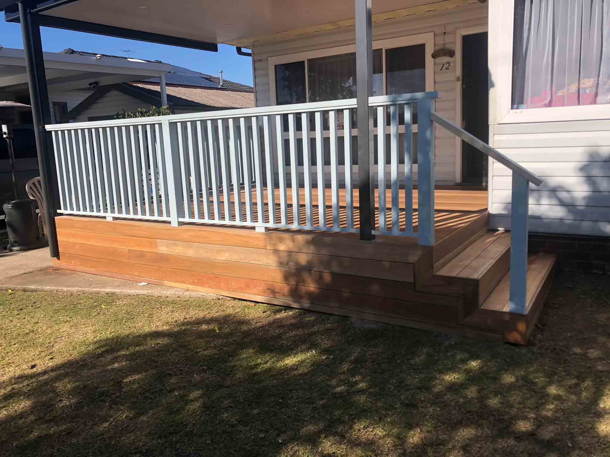 Timber deck with white balustrade and steps at a front door