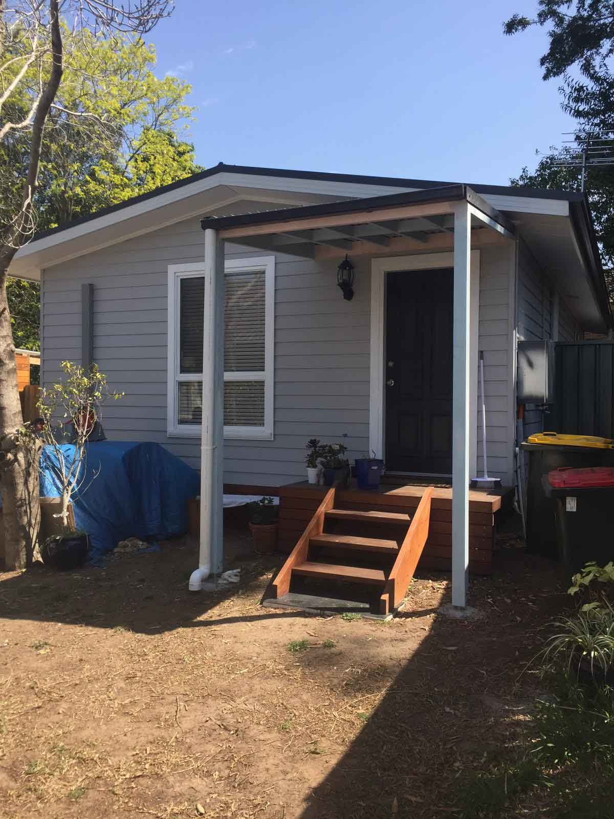Timber steps and landing at the front door of a weatherboard cottage