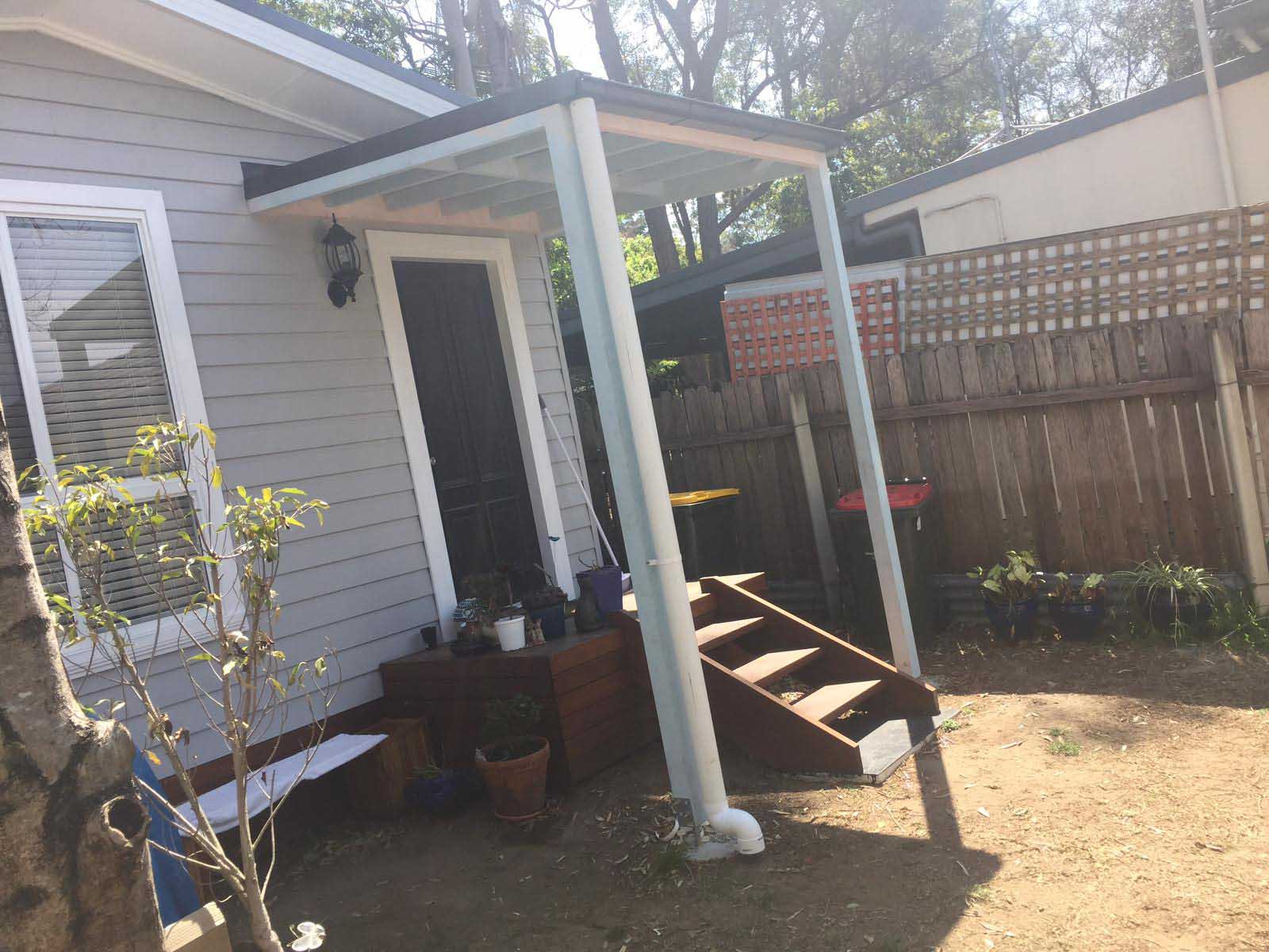 Timber steps and planter box beside a covered front entry