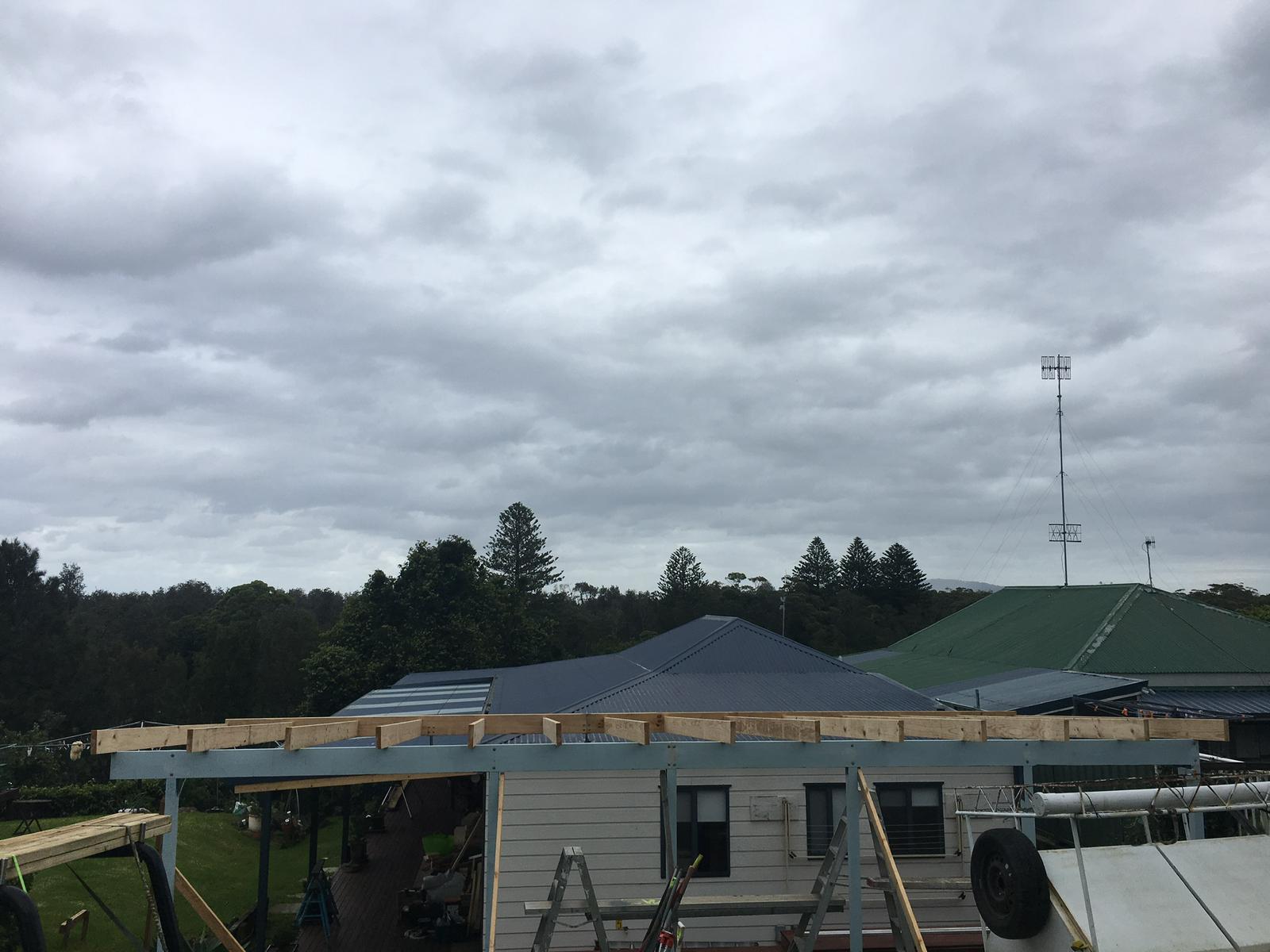 Pergola frame going up over the deck of a weatherboard house