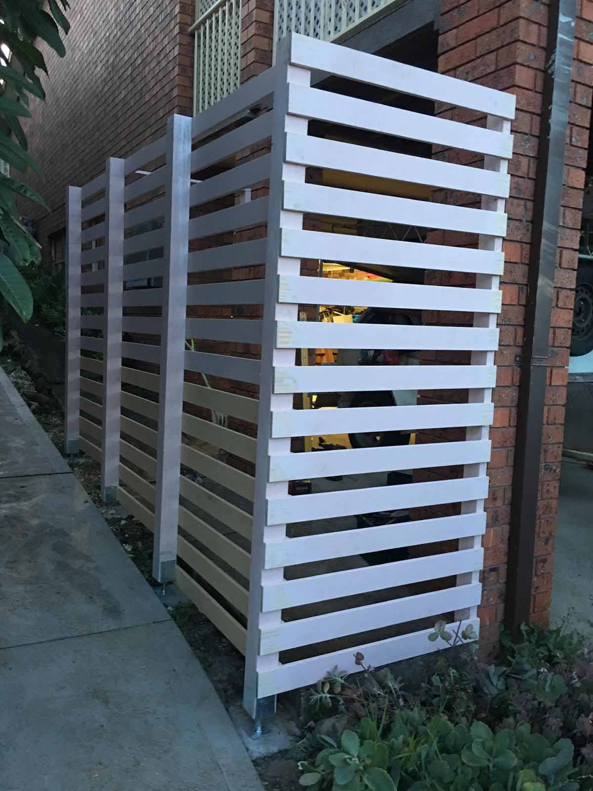 White slatted screen panels along the side of a brick house