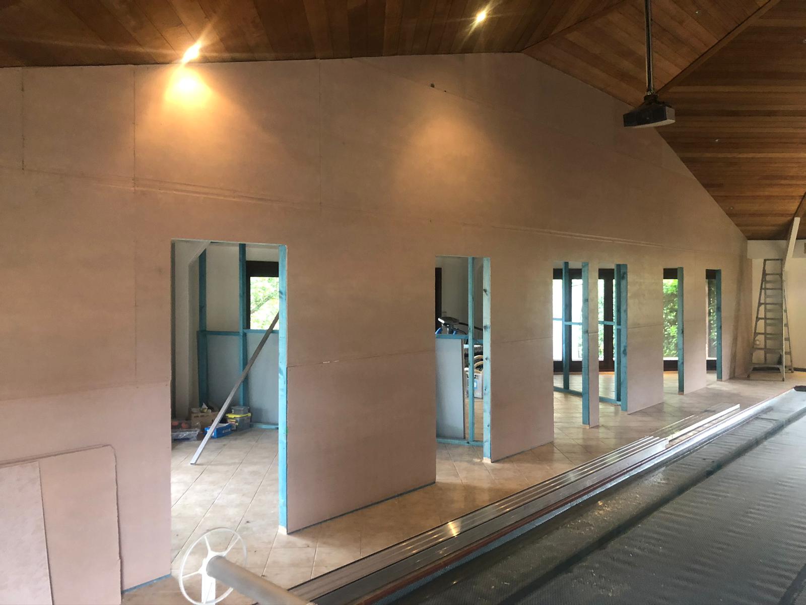 Large room under construction with a timber-lined raked ceiling